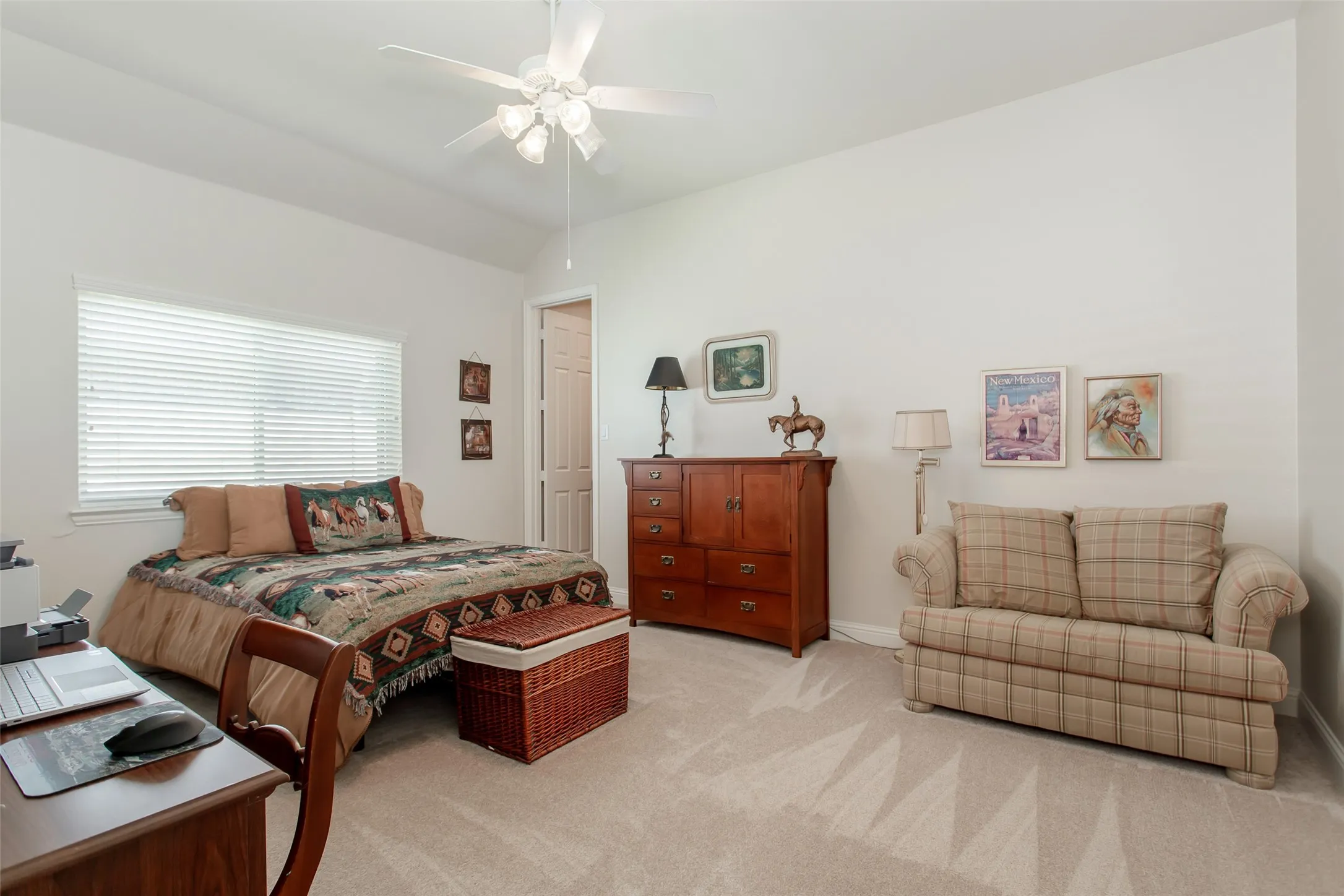 Neutral tone wall paint, carpeted flooring, window with blinds, ceiling fan with light fixture, and interior door