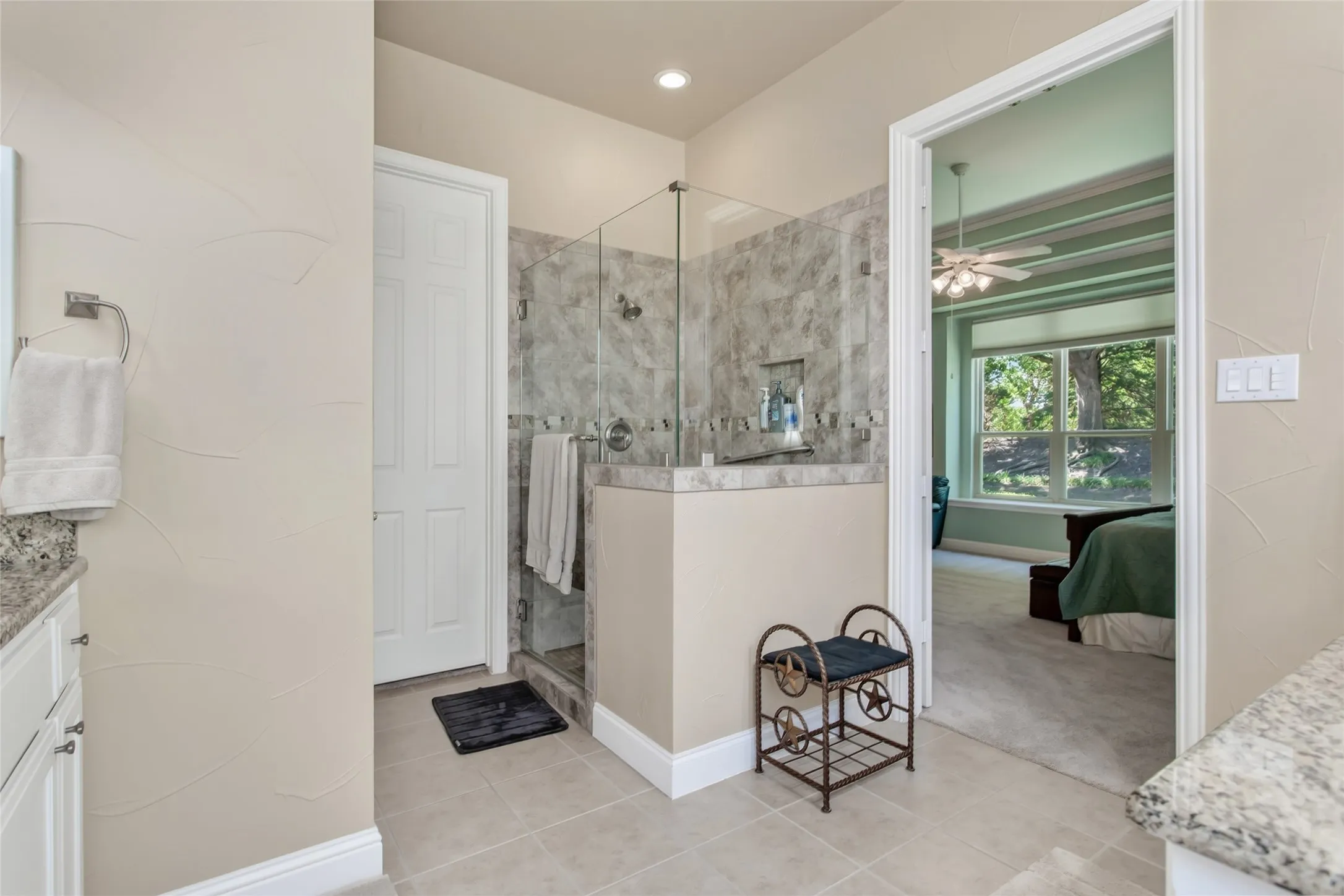 Walk-in shower with glass enclosure, tiled walls, and a built-in niche