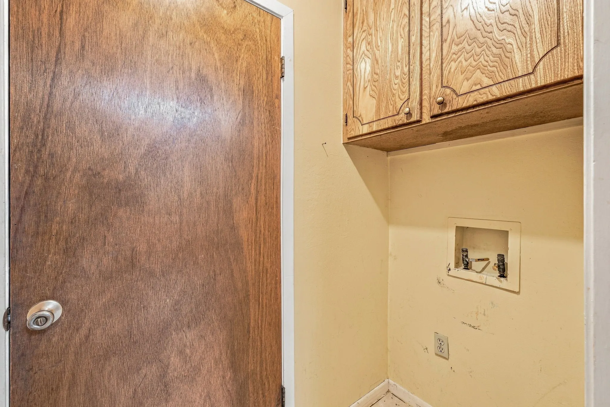 Built-in overhead wood-finish cabinetry, laundry hookups, and a wood-finish door