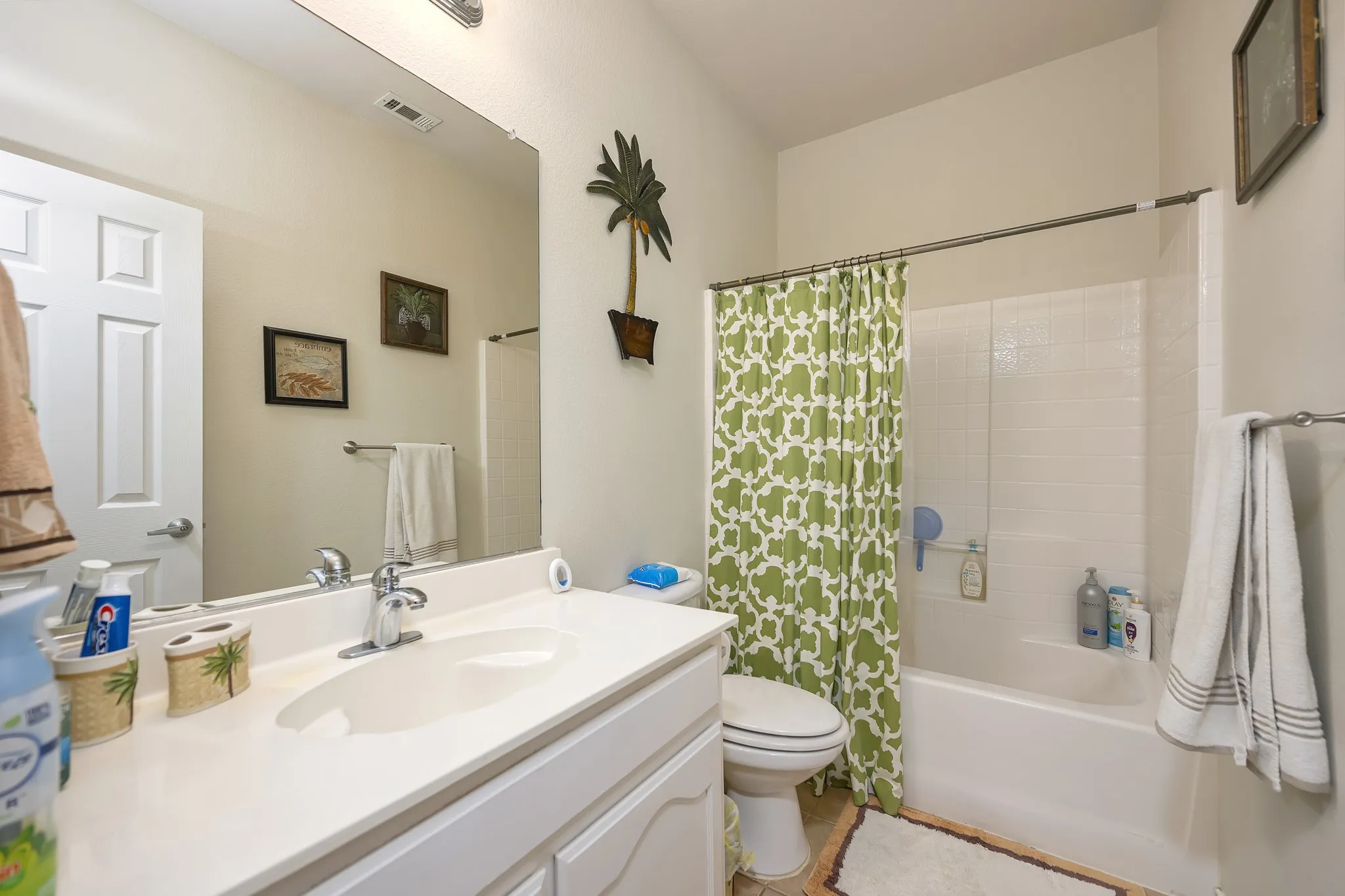 Vanity with integrated sink, chrome faucet, and expansive wall mirror