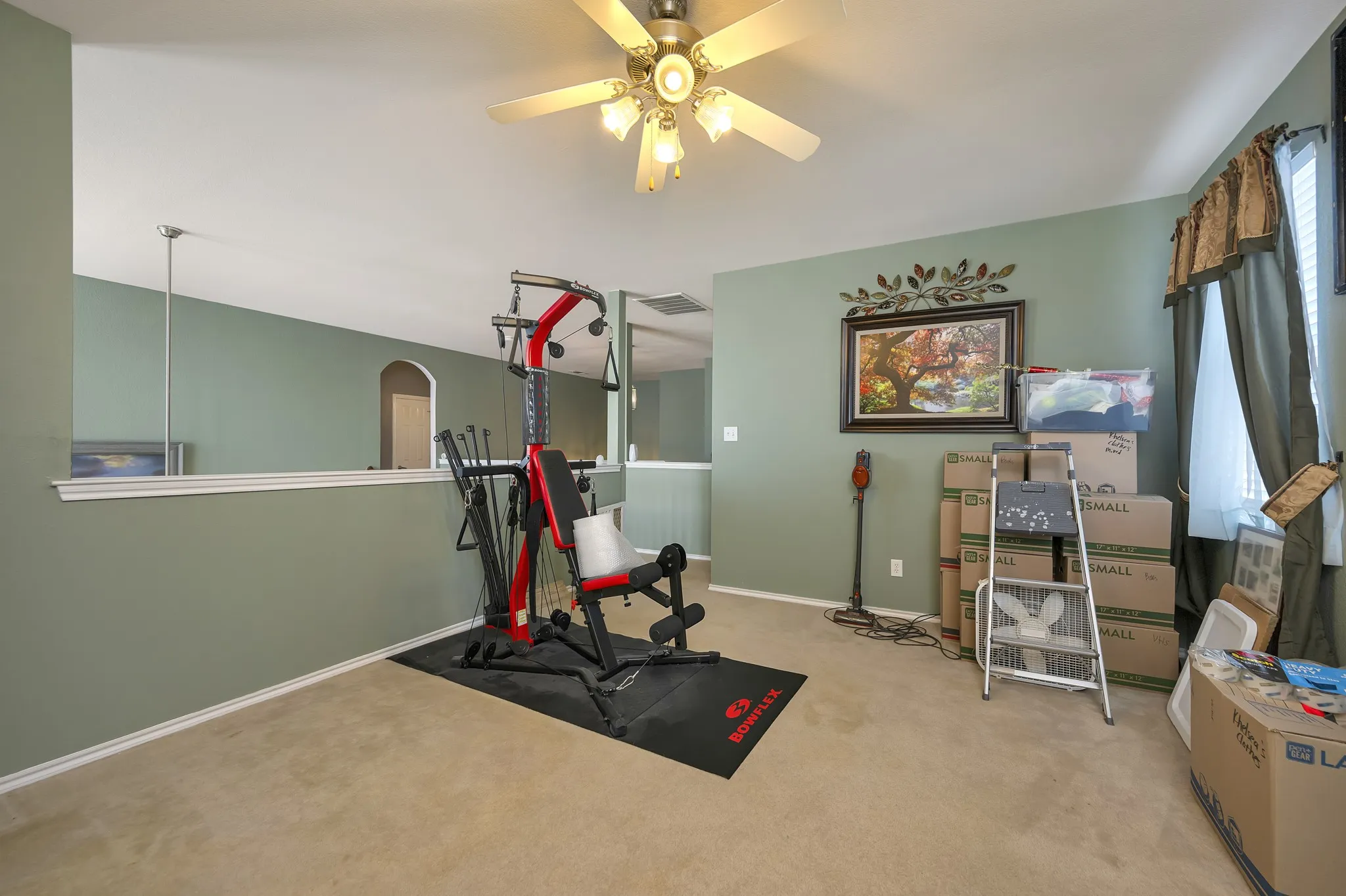 Recessed ceiling, ceiling fan with integrated lighting, neutral wall paint, carpeted flooring