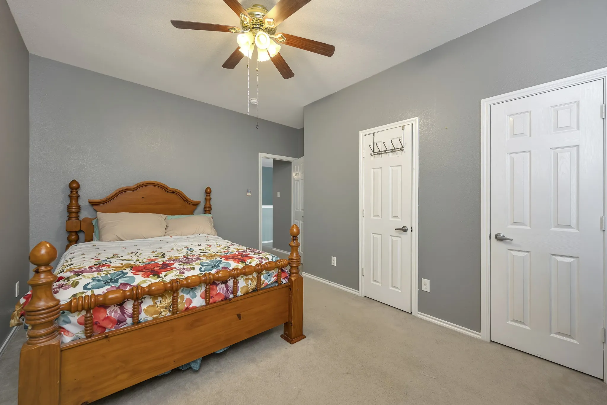 Neutral wall paint, ceiling fan, and carpeted flooring