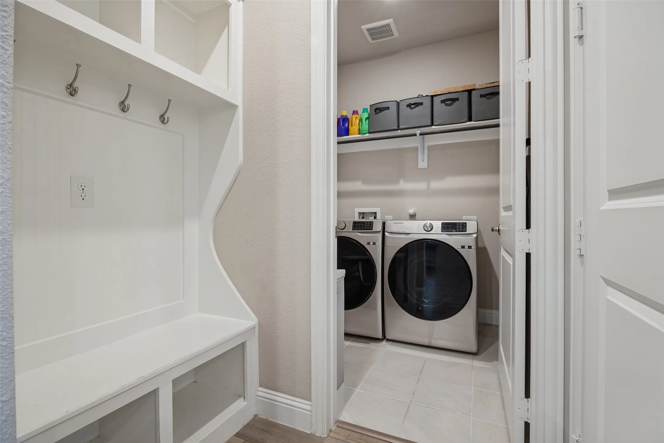 Built-in mudroom bench with storage compartments, upper shelving, and coat hooks