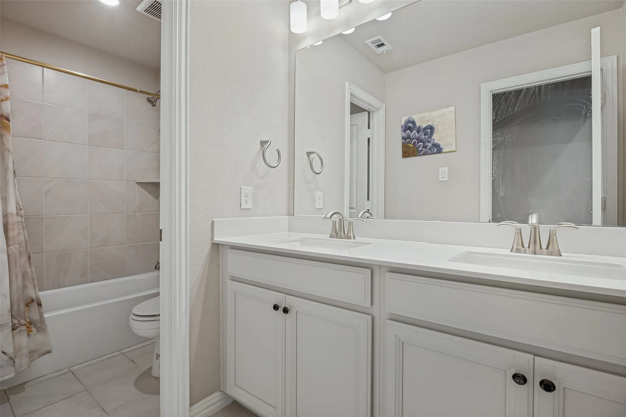 Dual vanity with integrated sinks, white cabinetry, and brushed nickel fixtures