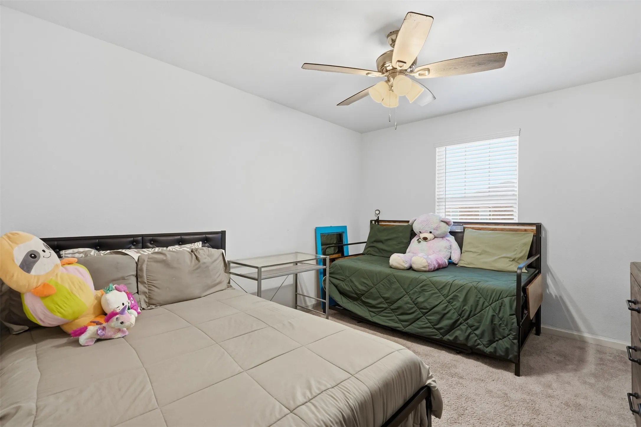 Carpeted room with a ceiling fan, a window with horizontal blinds, and neutral wall paint
