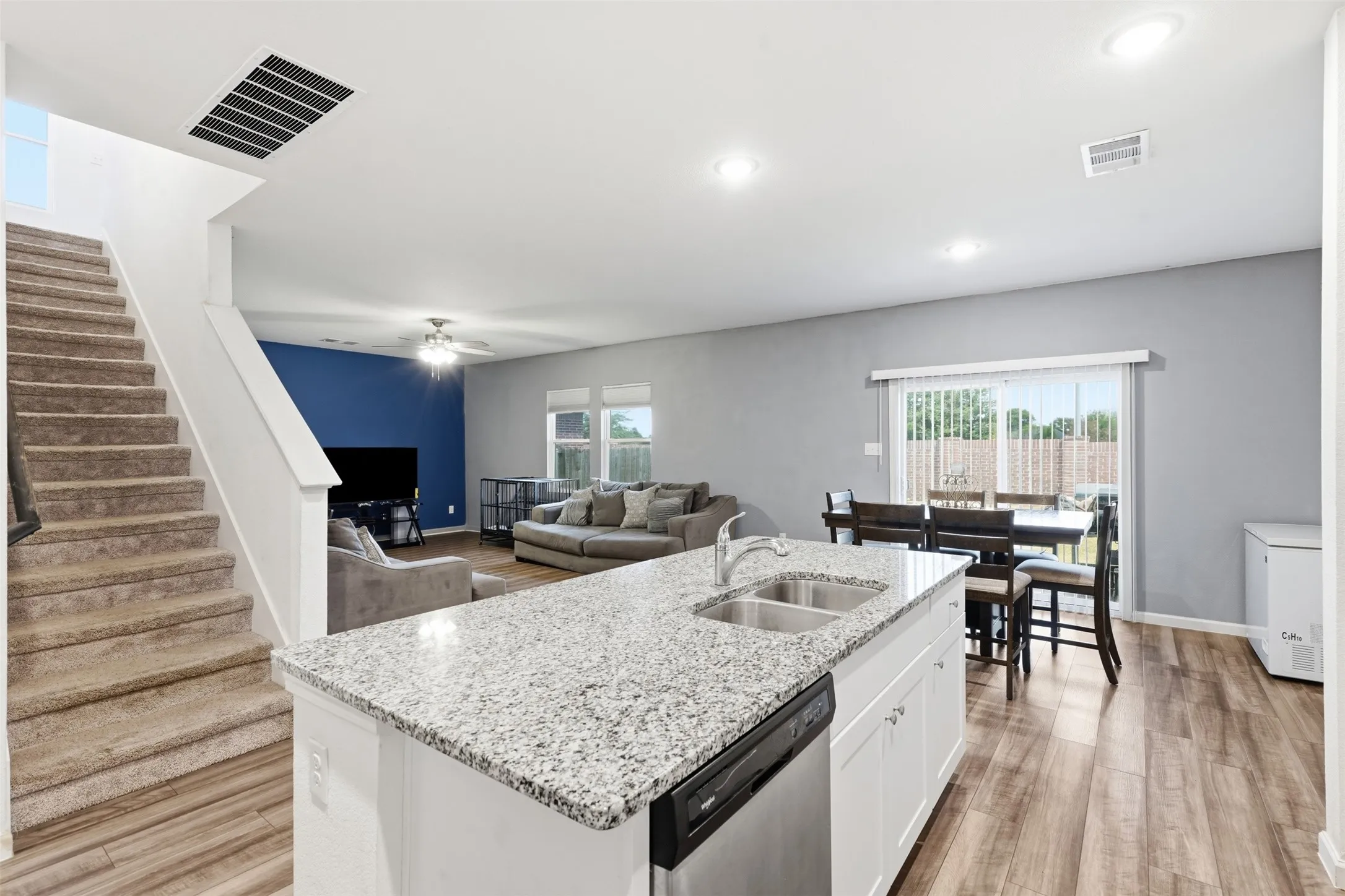 Kitchen island with a granite-style countertop and undermount double sink