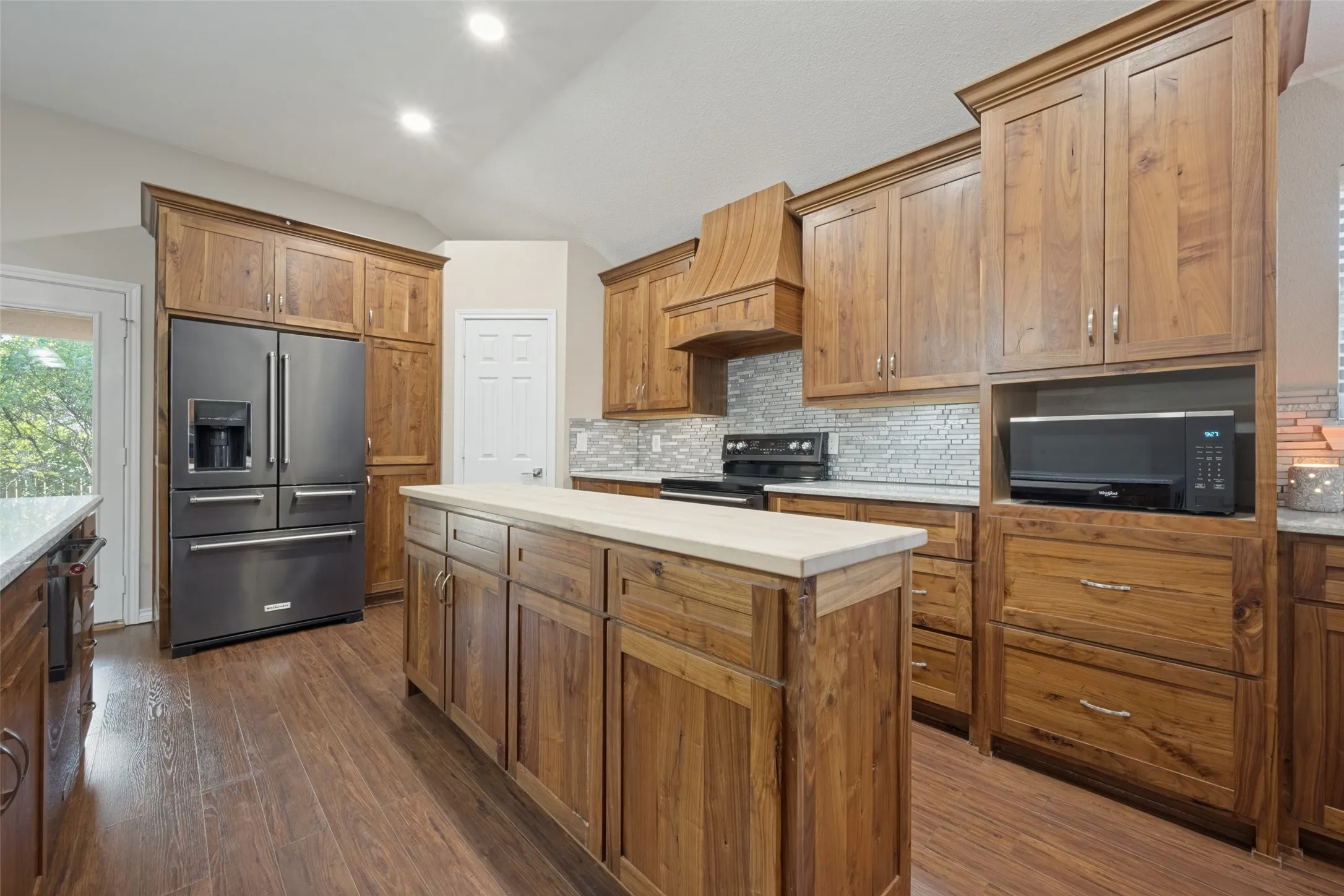 Beautifully updated rustic walnut cabinets with granite countertops and large butcher block island.