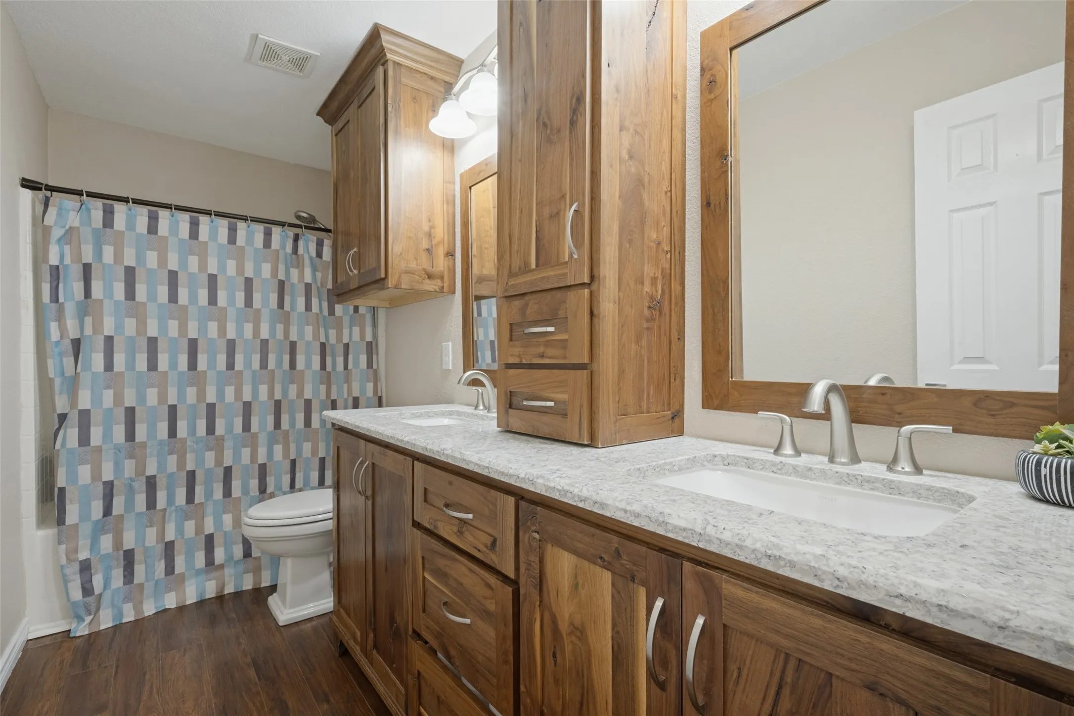 Double sink with custom rustic walnut cabinets in hall bathroom.