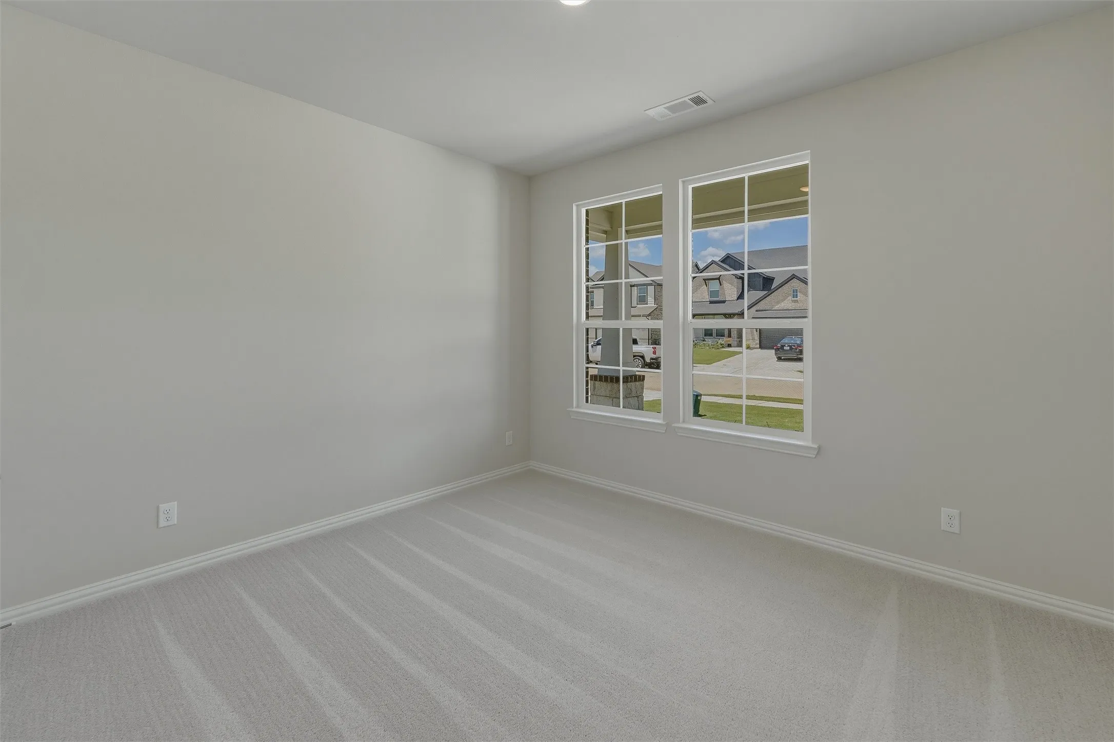 Room with light gray walls, white trim, and light gray patterned carpeting