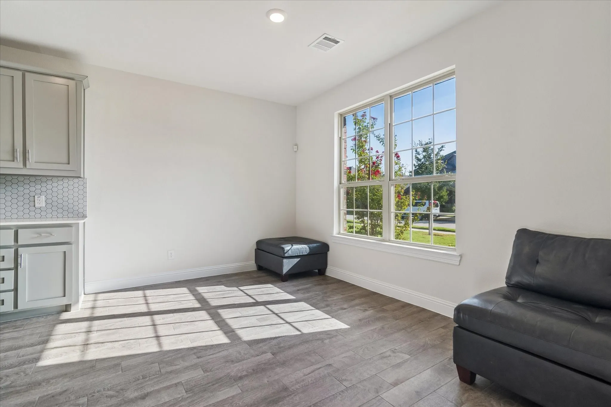 Wood-finish flooring, recessed lighting, and a large multi-pane window