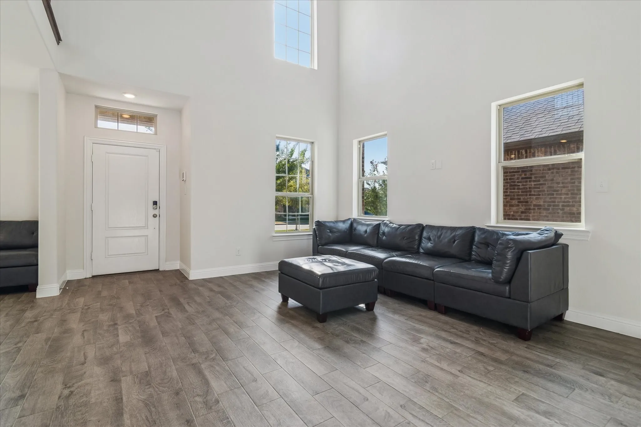 Wood-finish flooring throughout, bright white walls, and multiple windows