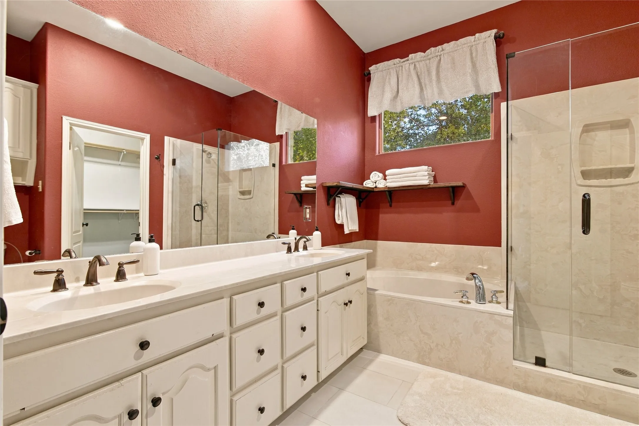 Double vanity with undermount sinks, built-in bathtub, and a glass-enclosed shower