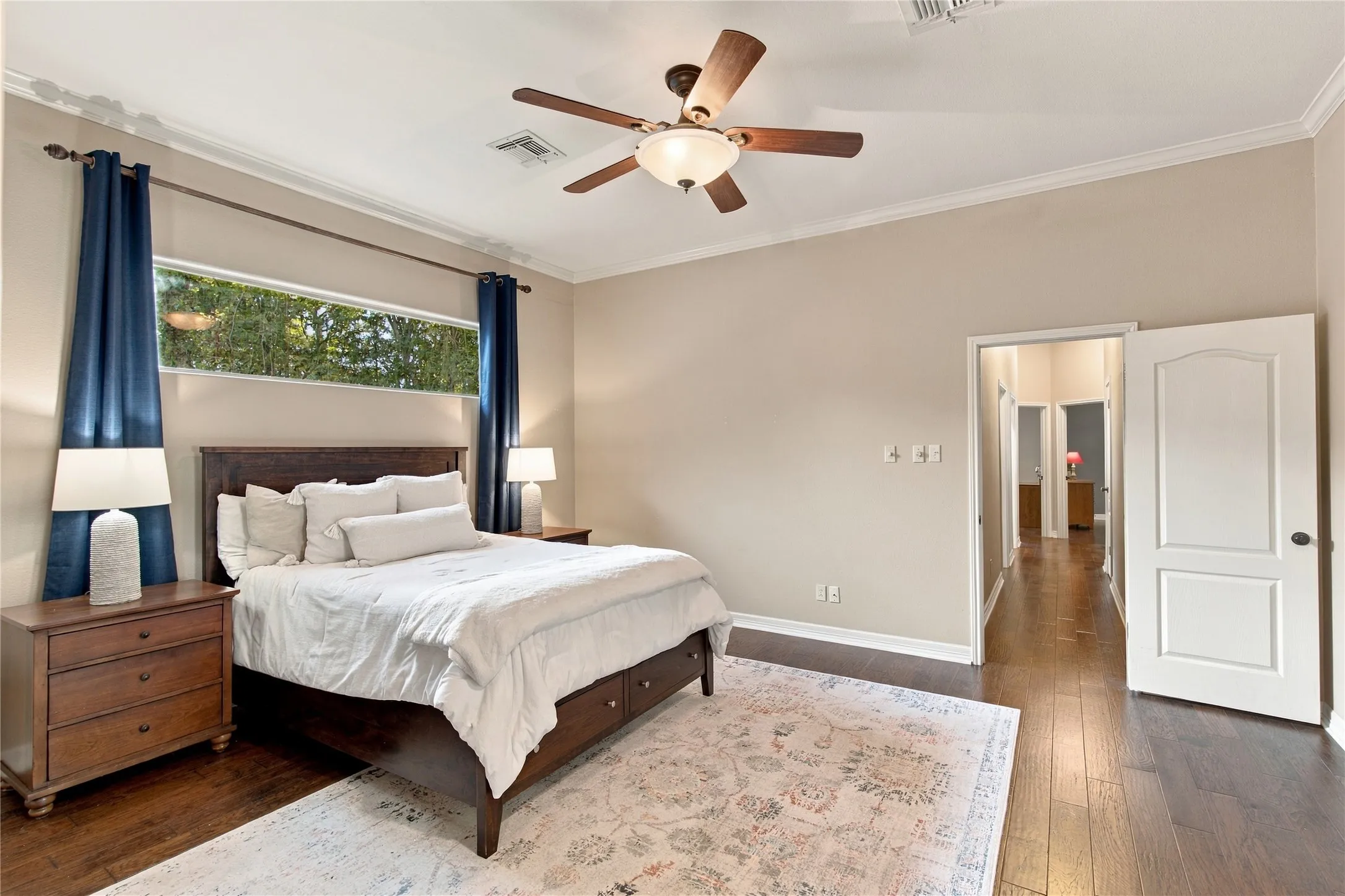 Dark wood-finish flooring with a ceiling fan light fixture