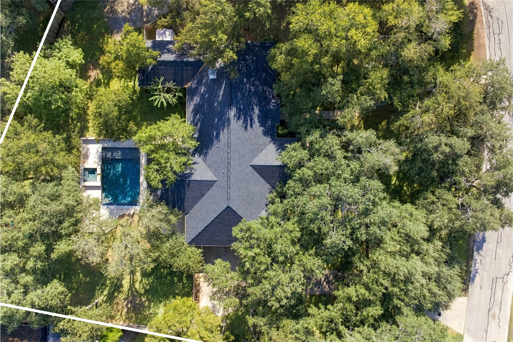 Aerial view showcasing the home surrounded by mature trees, expansive lawn, and a private setting. Lot size 1.0 acre and not all in view.