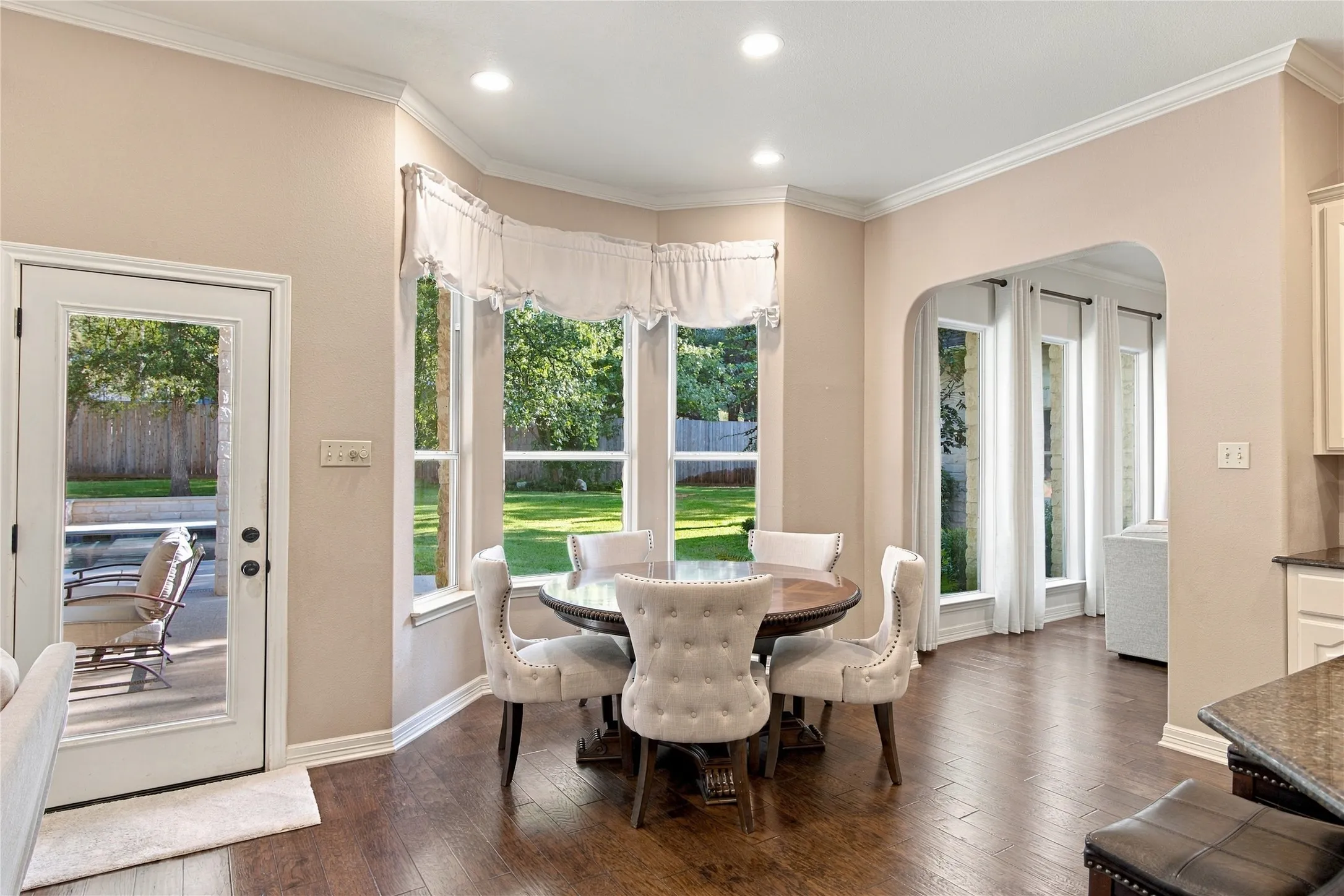 Bay window with multiple glass panels, recessed lighting, wood-finish flooring, and a glass-paneled exterior door