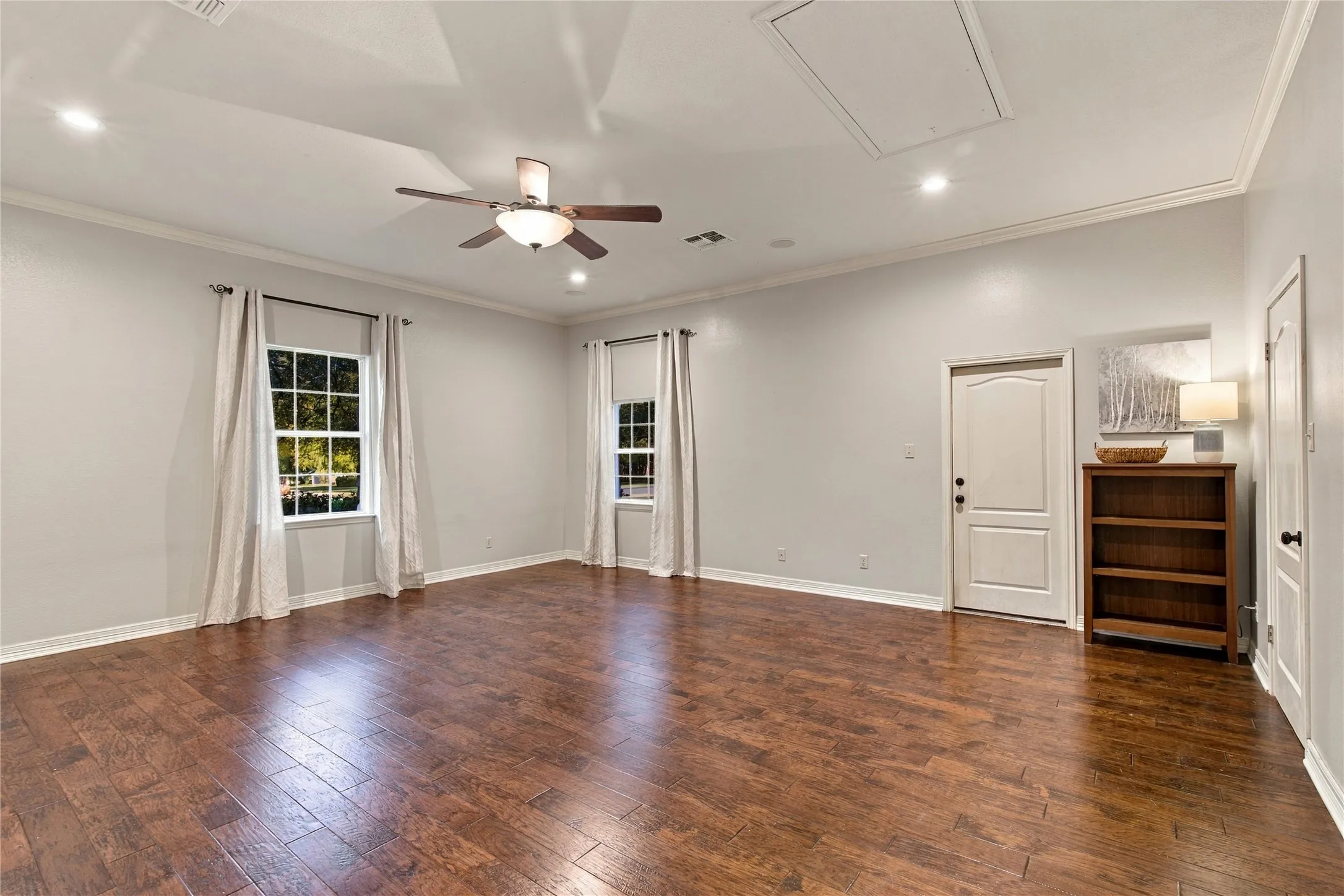 Wood-finish flooring, ceiling fan, recessed lighting, crown molding, and white trim