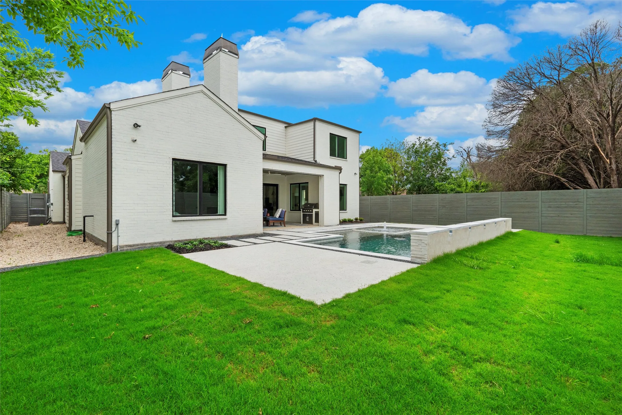 Rear view of house featuring a fenced in pool, a patio, and a yard large enough for kids and pets to play!