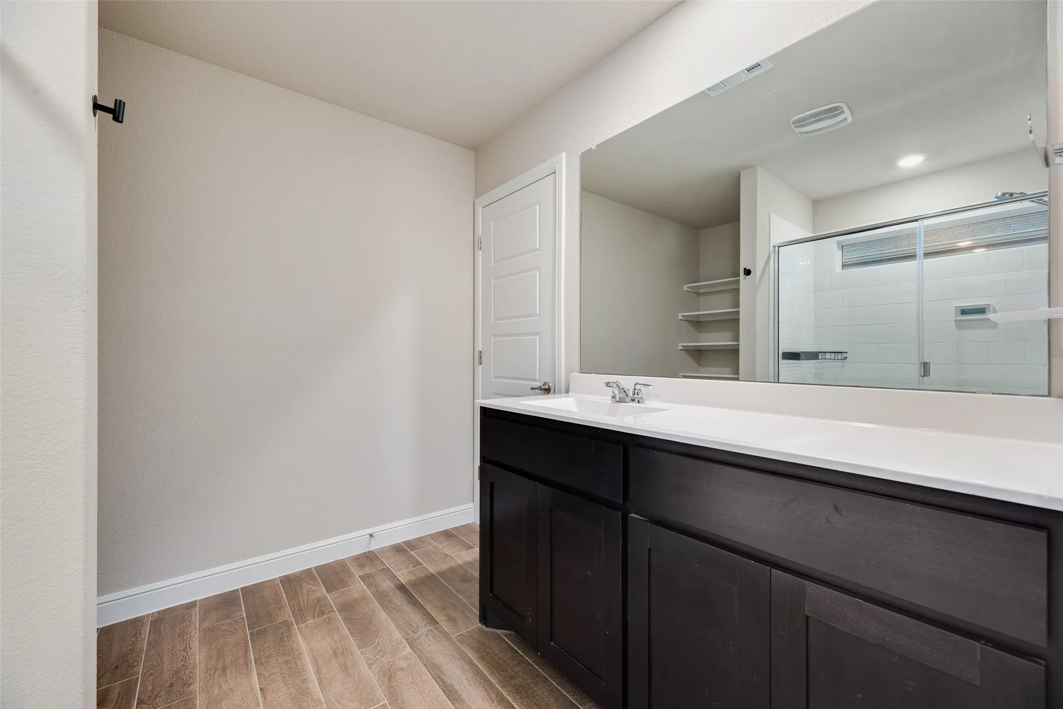 Dark wood-finish vanity with a white countertop and integrated sink
