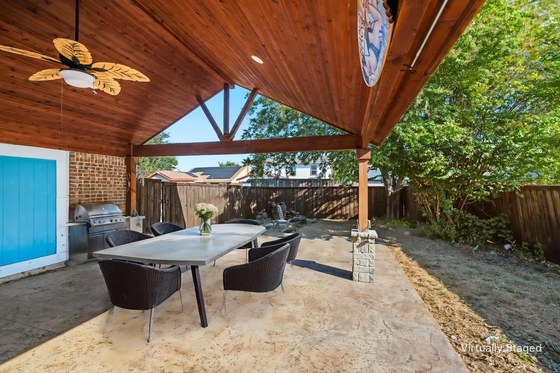 Covered patio with a wood-finish ceiling, exposed beams, and a ceiling fan