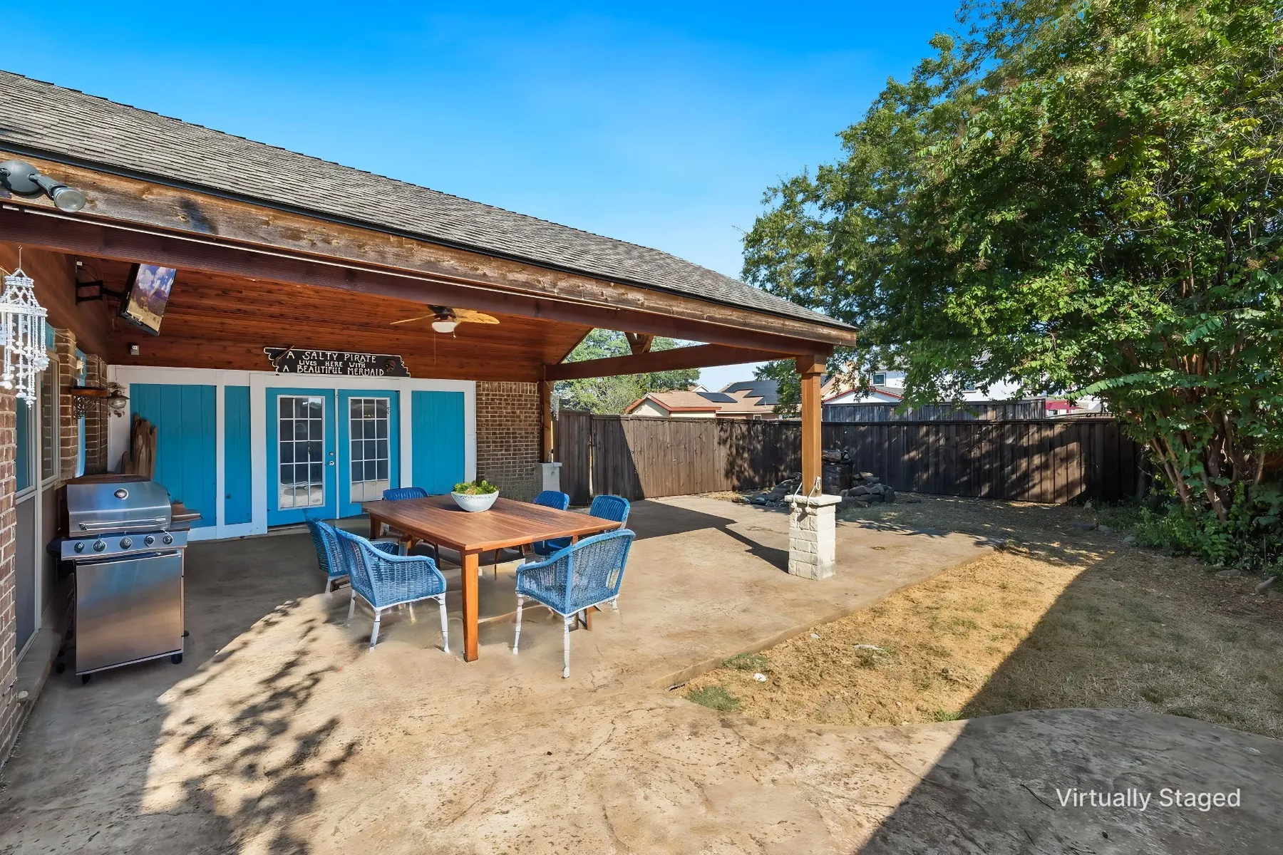 Virtually staged photo - showcasing what your outdoor entertainment space could look like. Covered patio with a wood-finish ceiling, exposed beams, and a ceiling fan