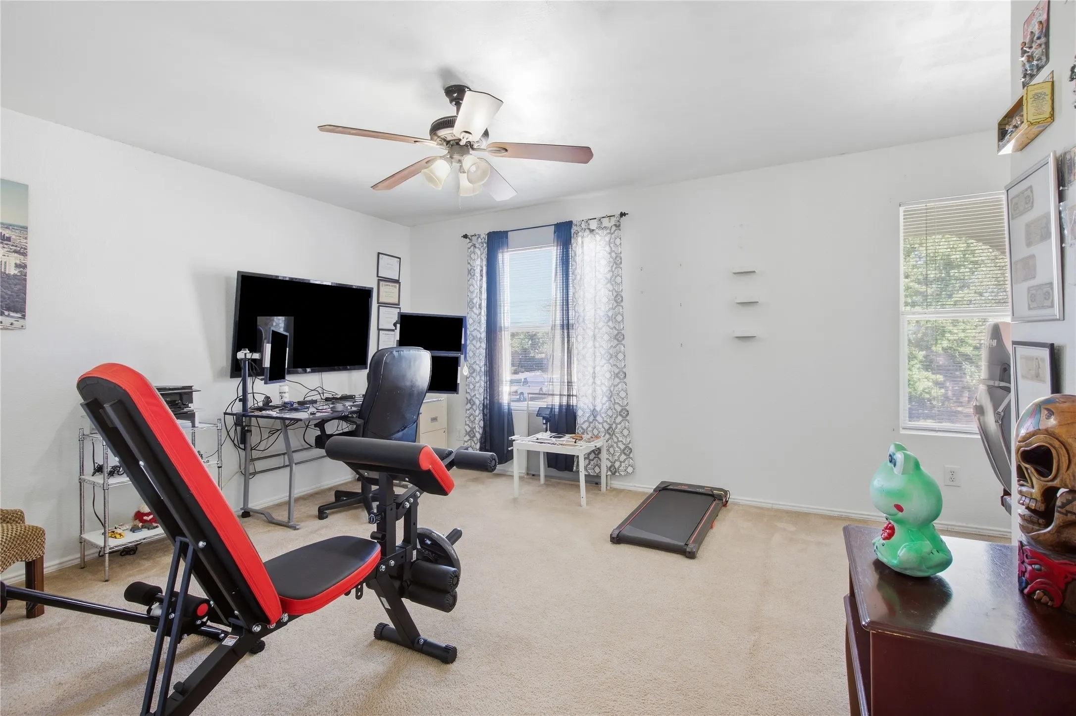 Recessed lighting, ceiling fan, and multiple windows illuminate this room with light-toned carpeting