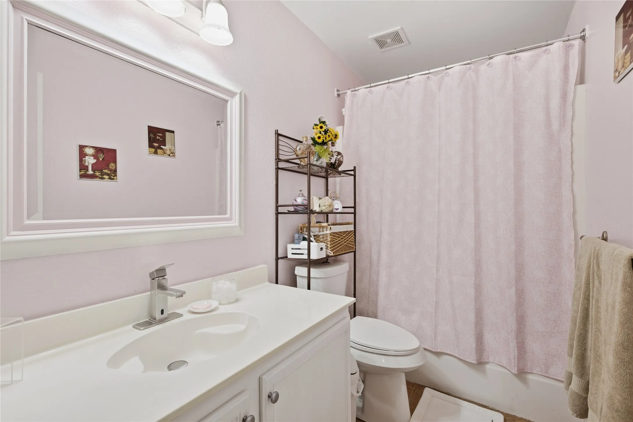 White vanity with integrated sink, brushed nickel faucet, and framed mirror