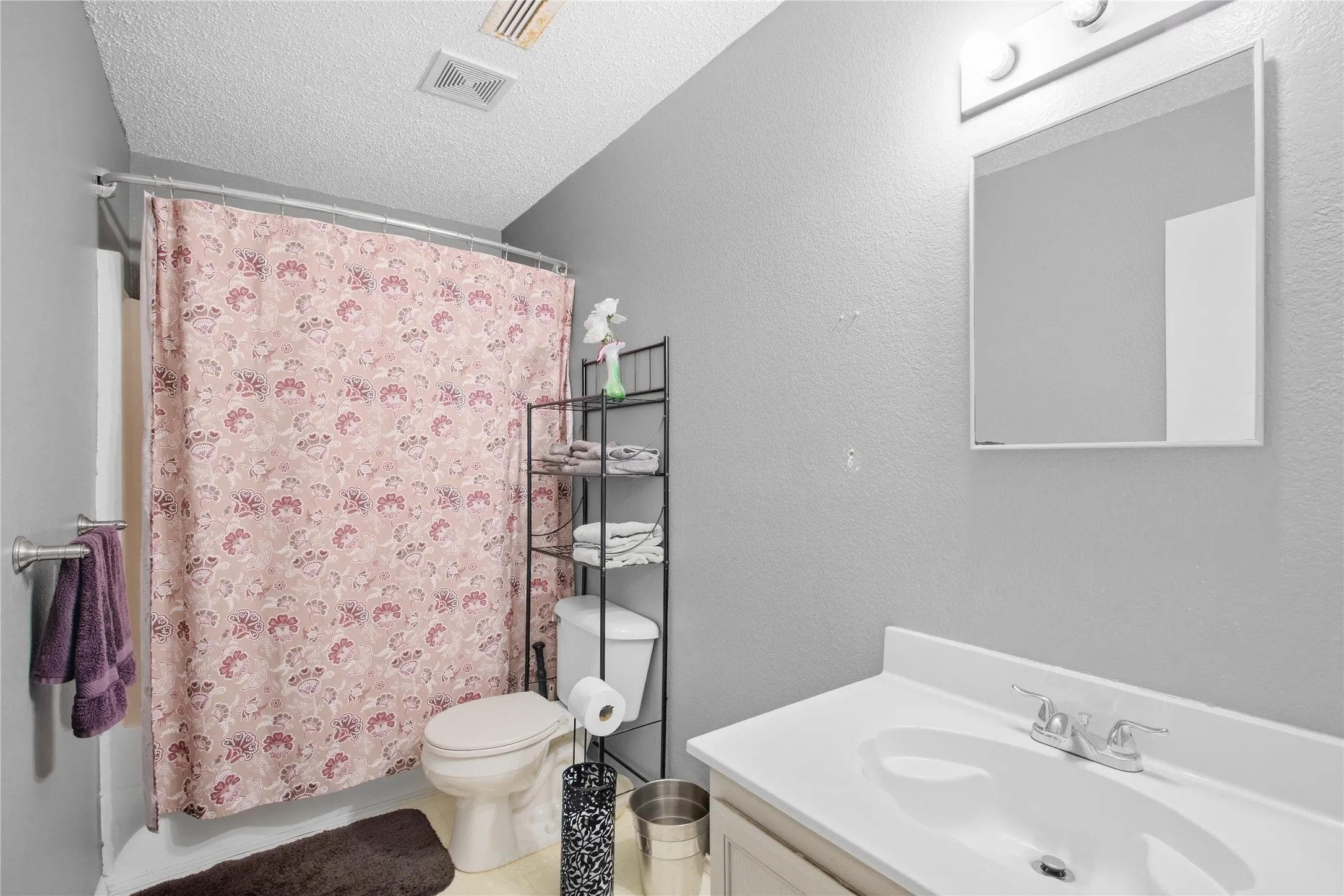 Bathroom featuring a built-in vanity with an integrated sink and chrome faucet, a shower/tub combination, and a ceiling-mounted light fixture