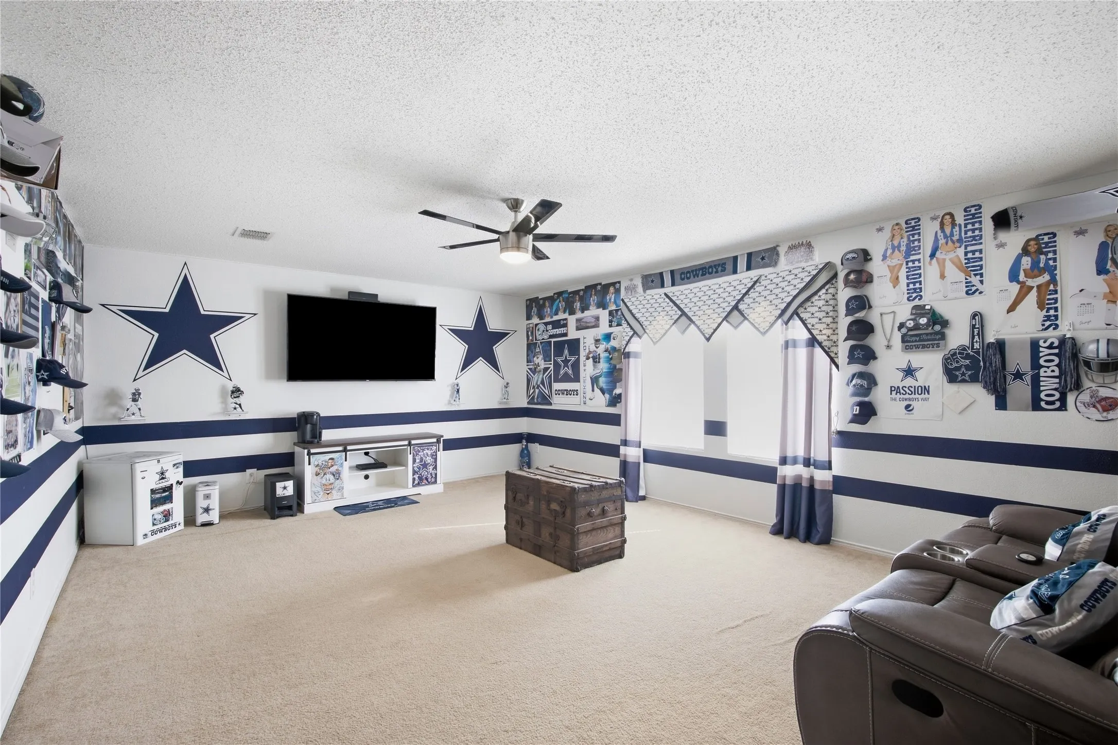 Recessed media wall, ceiling fan, carpeted flooring, and a window with custom valance