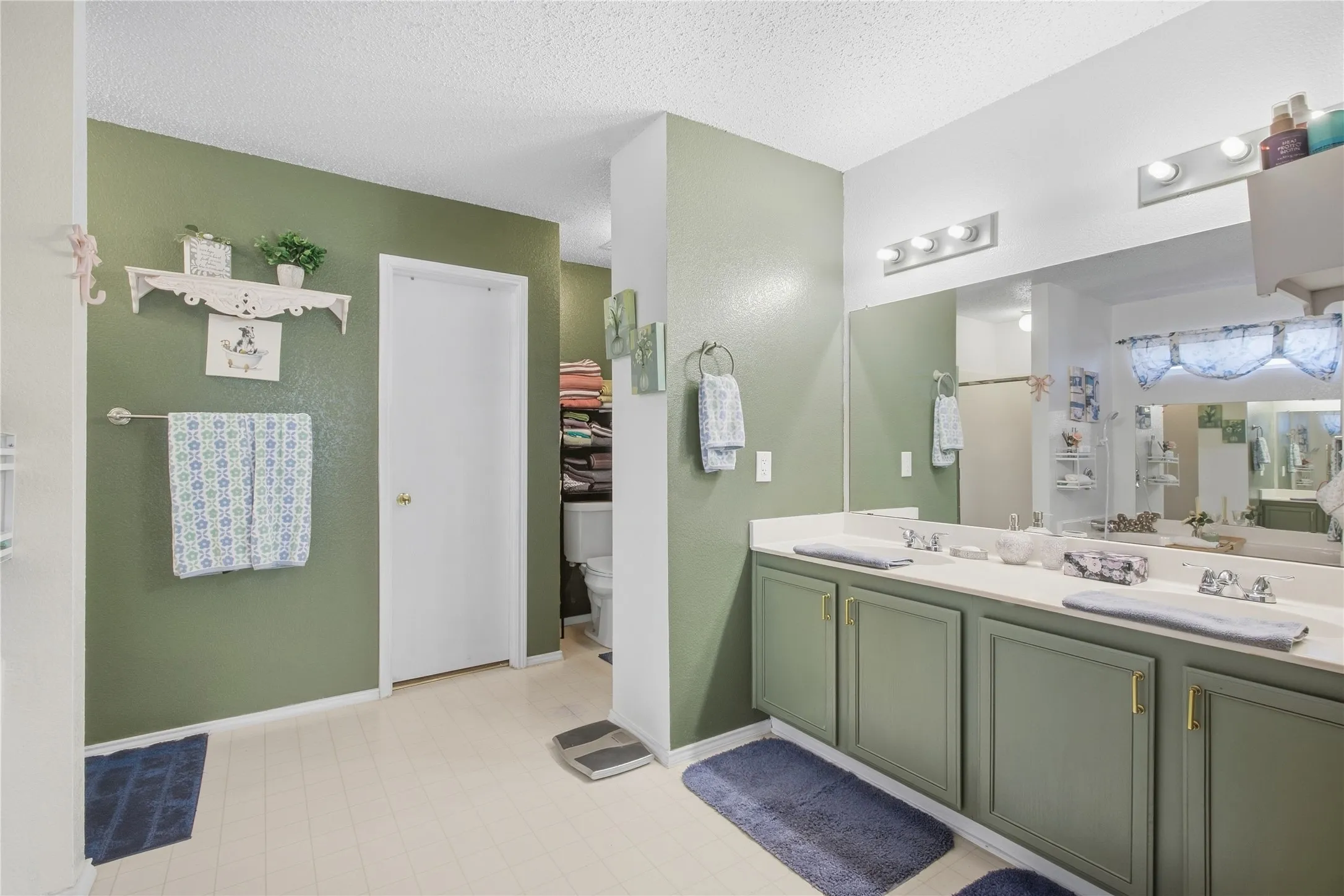 Dual vanity with integrated sinks, expansive mirror, and overhead lighting