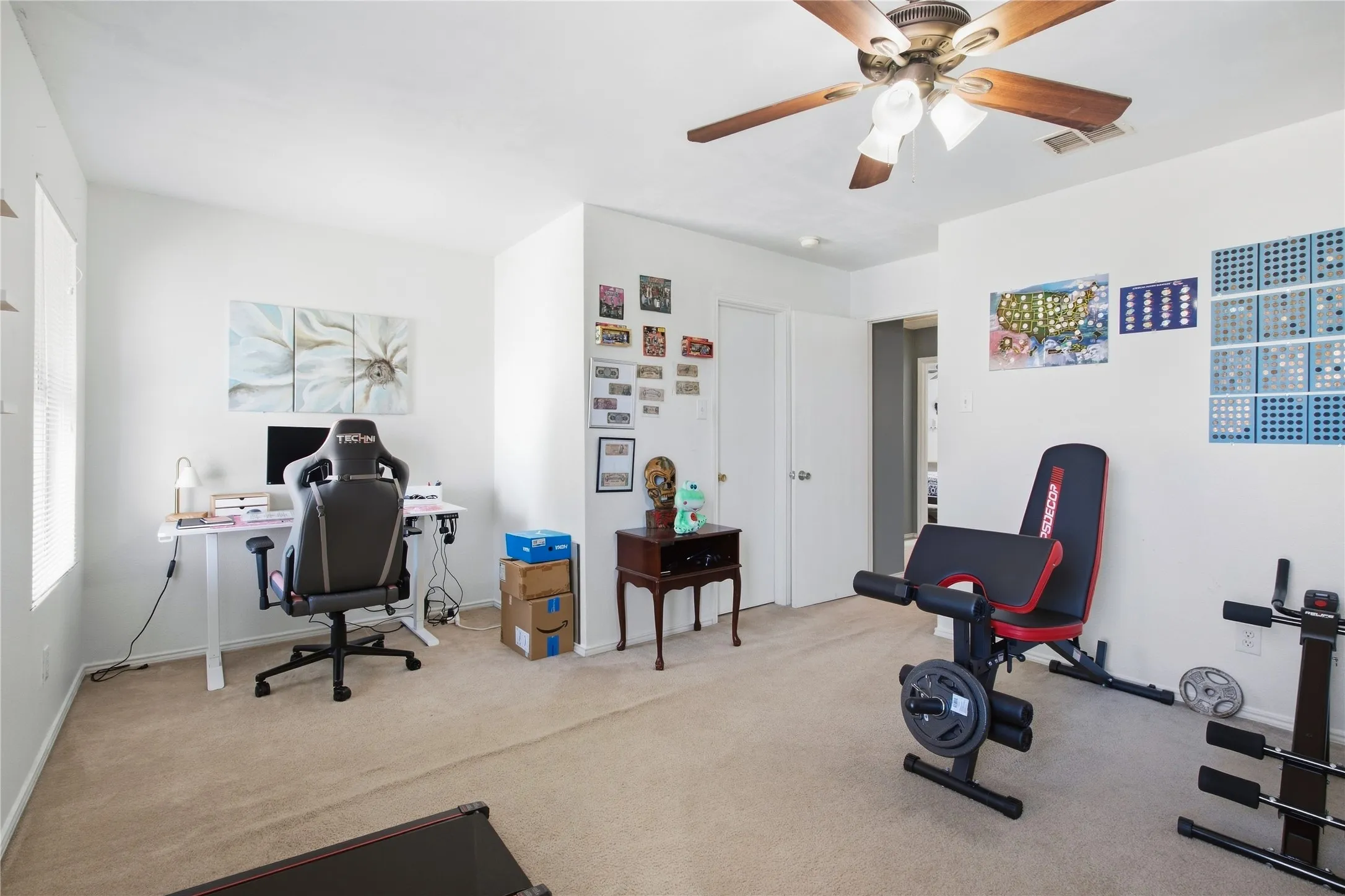 Carpeted flooring, a ceiling fan with light fixture, and white painted walls