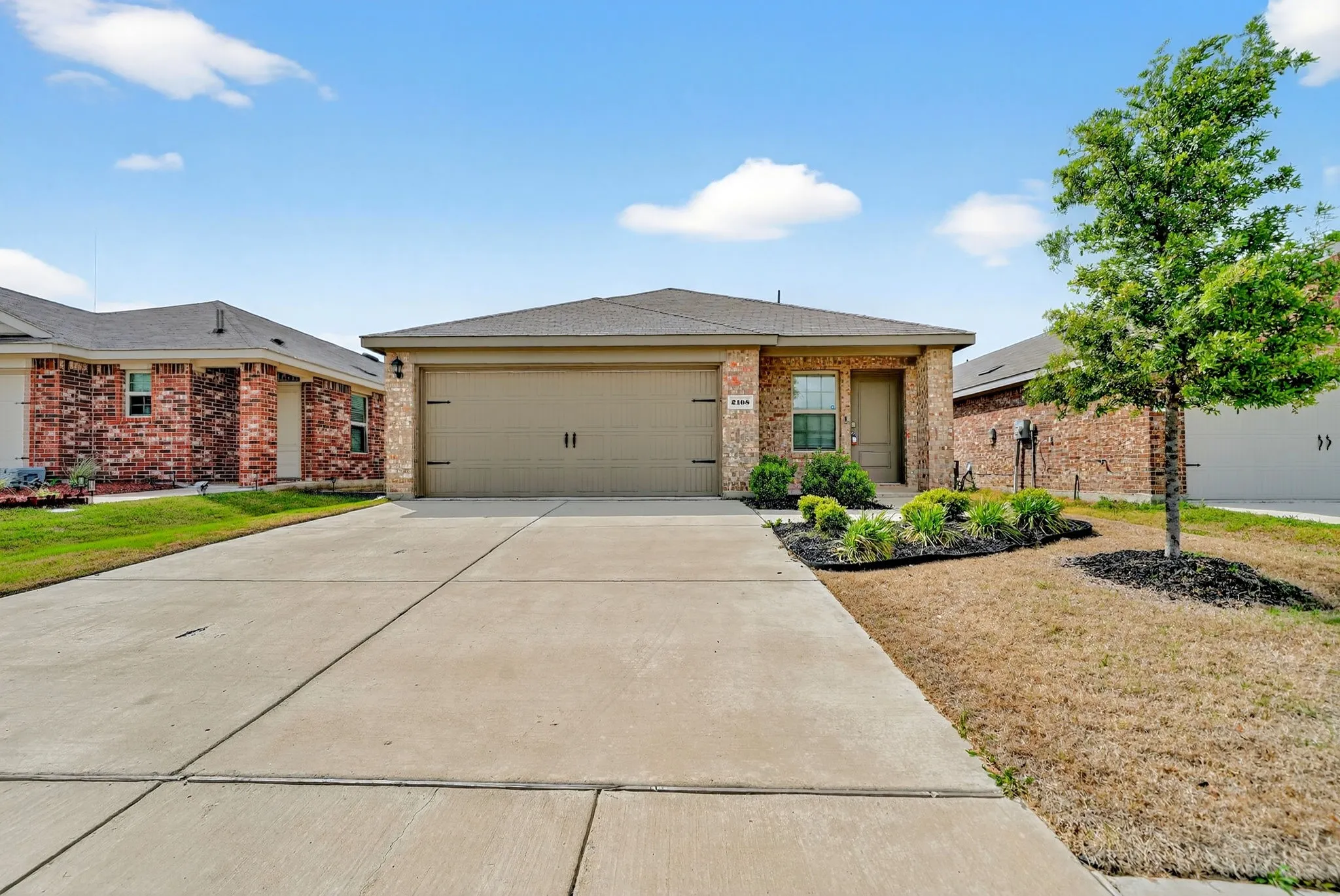 Brick exterior with a gabled roof and an attached two-car garage