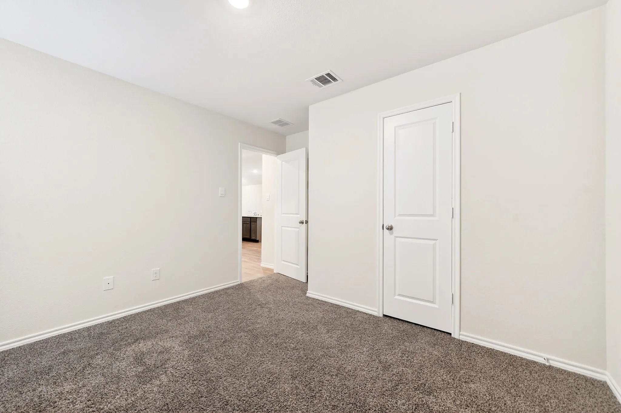 Plush carpet flooring, white painted walls, recessed lighting, and a solid panel interior door