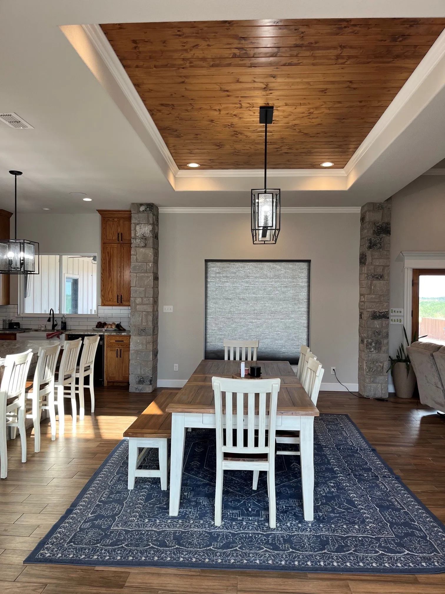 Tray ceiling with wood-finish paneling, recessed lighting, and a contemporary pendant fixture