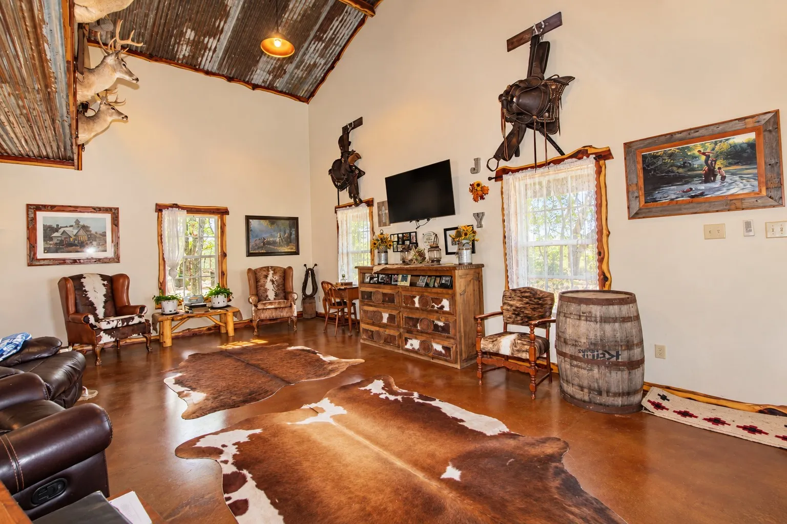 Vaulted ceiling with corrugated metal accent, light-toned walls, and wood-finish flooring