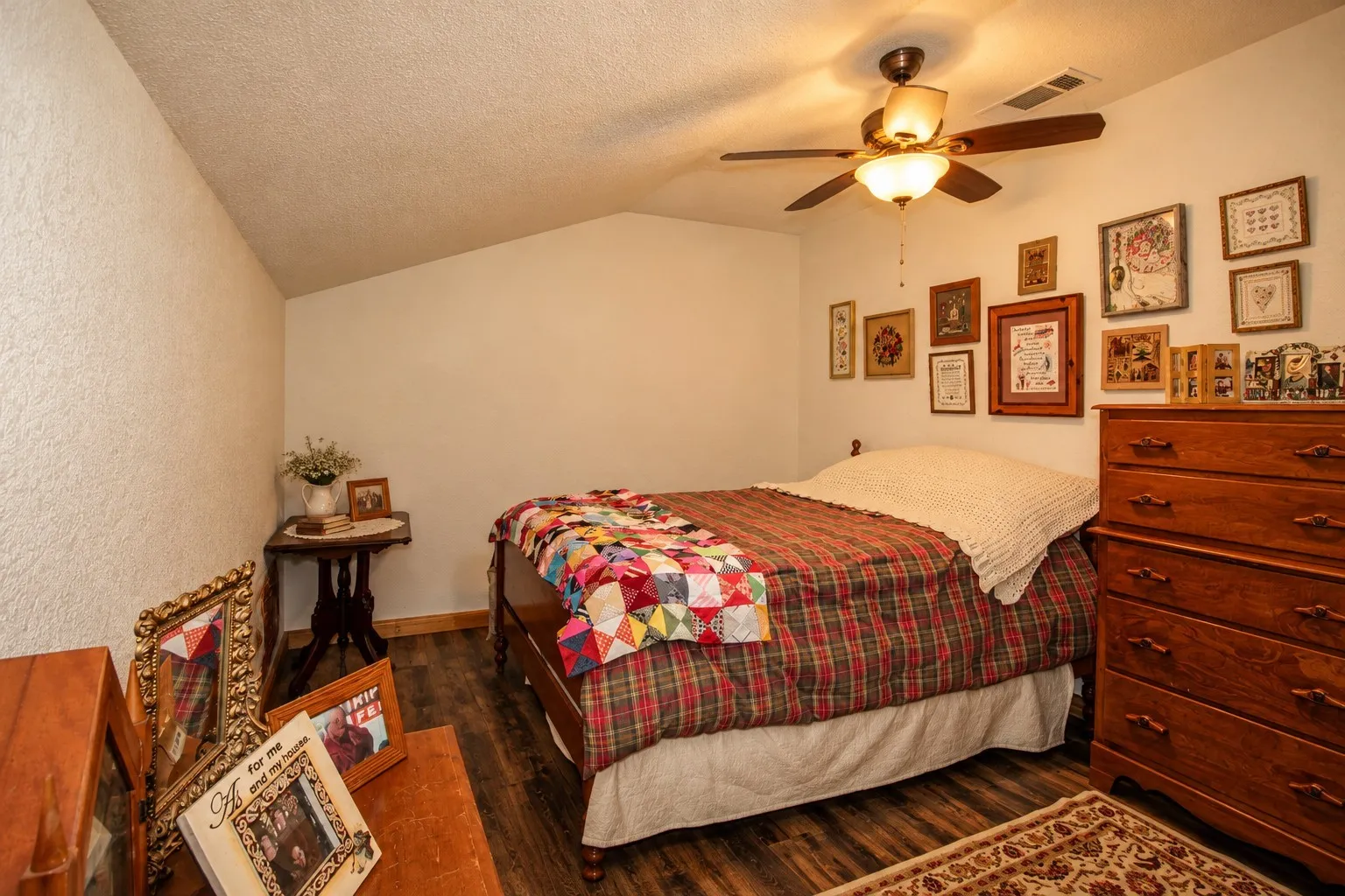 Wood-finish flooring, ceiling fan with integrated lighting, and a sloped ceiling