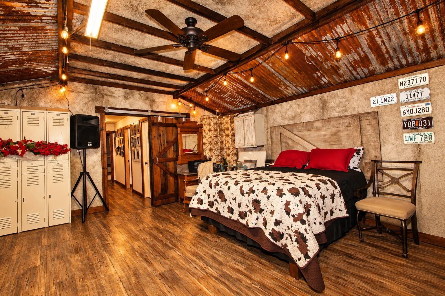 Kitchen featuring a corrugated metal ceiling, wood-finish flooring, custom cabinetry with a distressed finish, a center island with a wood base, and a tiled backsplash