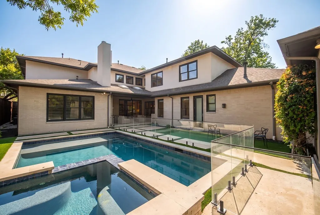 A sparkling inground pool and attached spa sit surrounded by green trees, ready for hot summer afternoons in Texas
