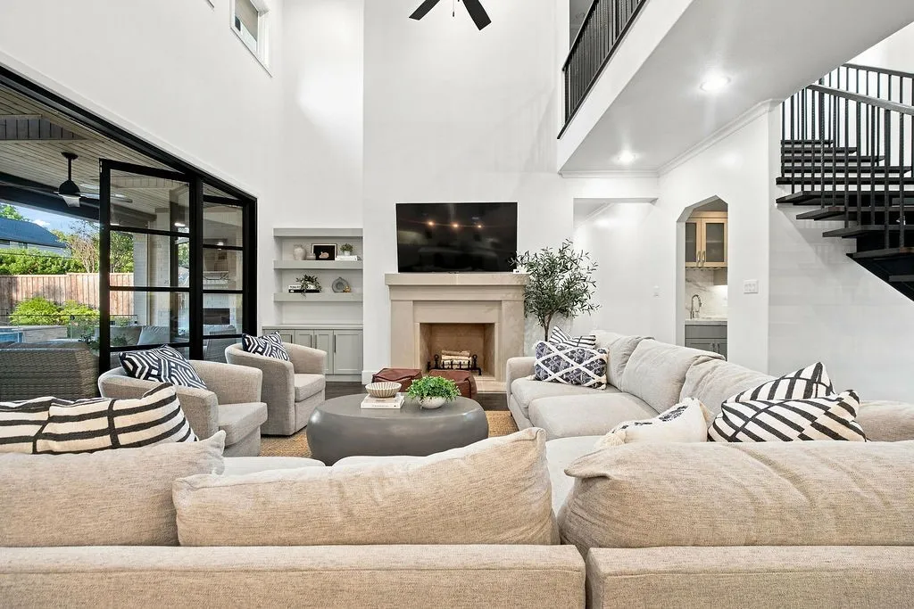 Soaring ceilings and an open overlook make the main living room feel expansive, connected, and full of natural light