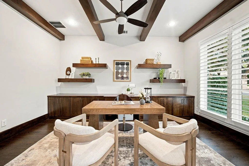 Exposed ceiling beams and built-in shelves give this dedicated home office a cozy, quiet feel for working from home or reading your favorite book