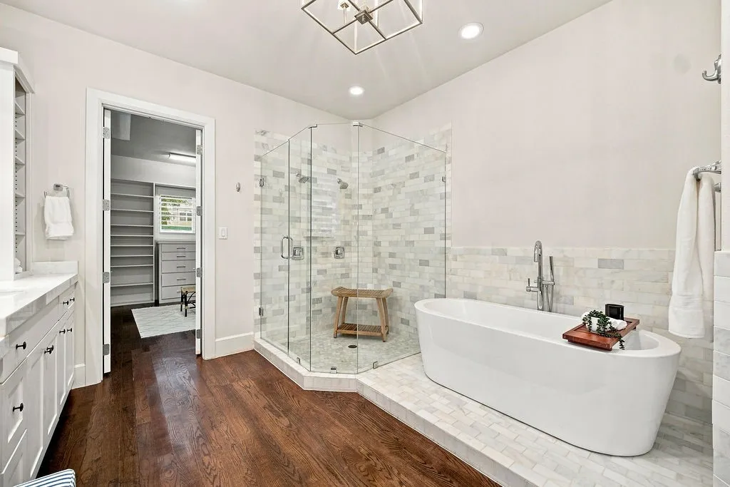 A large walk-in shower with rain shower heads and a standalone tub make your daily morning routine feel like a trip to the spa