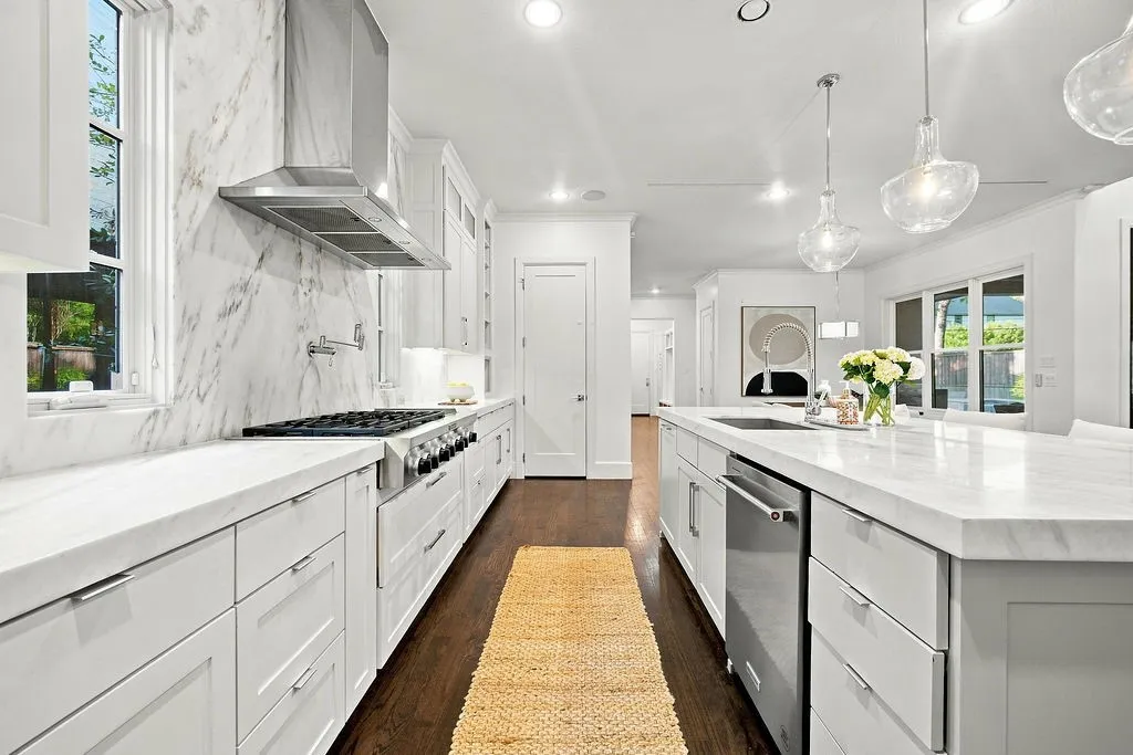 Double ovens, a gas cooktop, and a heavy-duty range hood make preparing big dinners simple and enjoyable