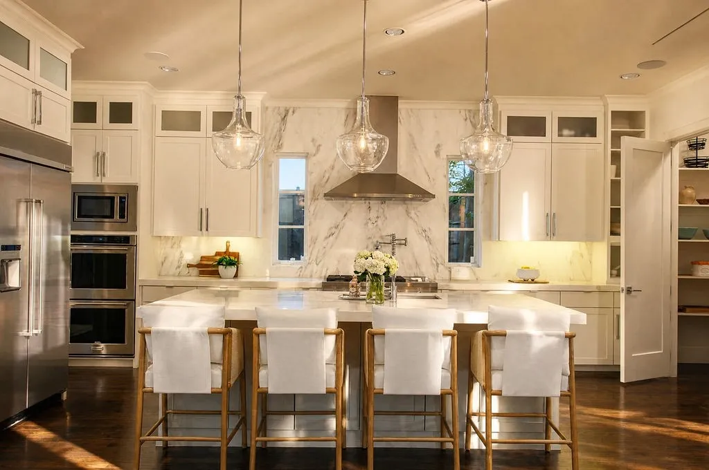Standing at the large quartz island, you immediately feel a sense of easy connection and warmth—it is the kind of space where morning coffee feels unhurried, and cooking dinner for family or friends feels completely natural and fun
