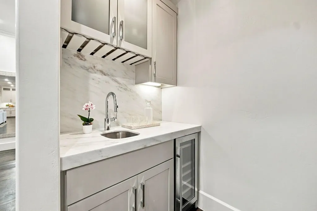 A dedicated wine fridge and built-in storage make it easy to mix a drink for friends without interrupting the main kitchen area