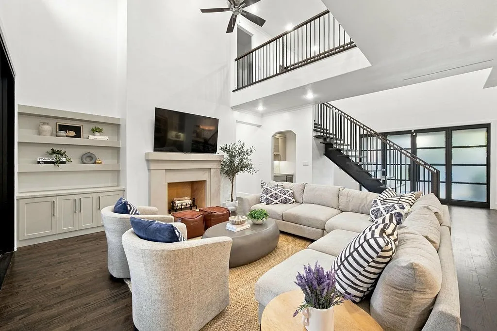 Double-height ceilings and a stone fireplace set the stage for cozy evenings or hosting friends around the fire