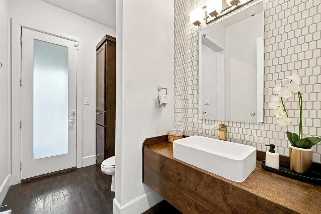 A unique wood vessel vanity and modern fixture bring style and convenience to this main-floor powder room