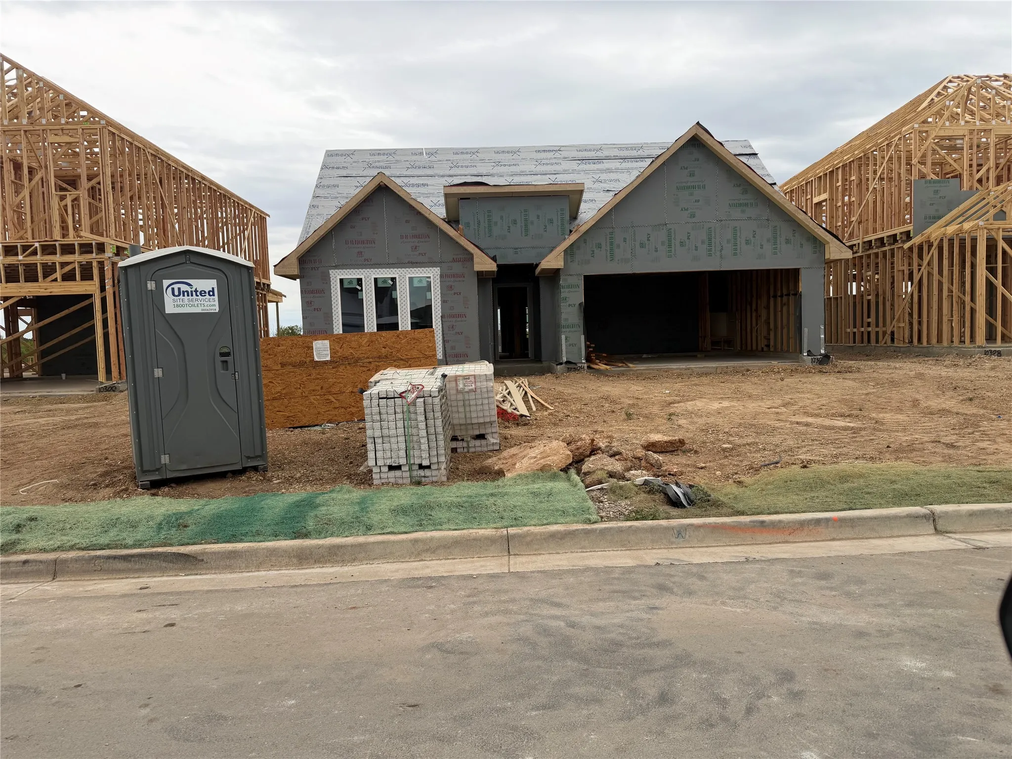 New construction residence with an attached garage, pitched rooflines, and multiple window openings