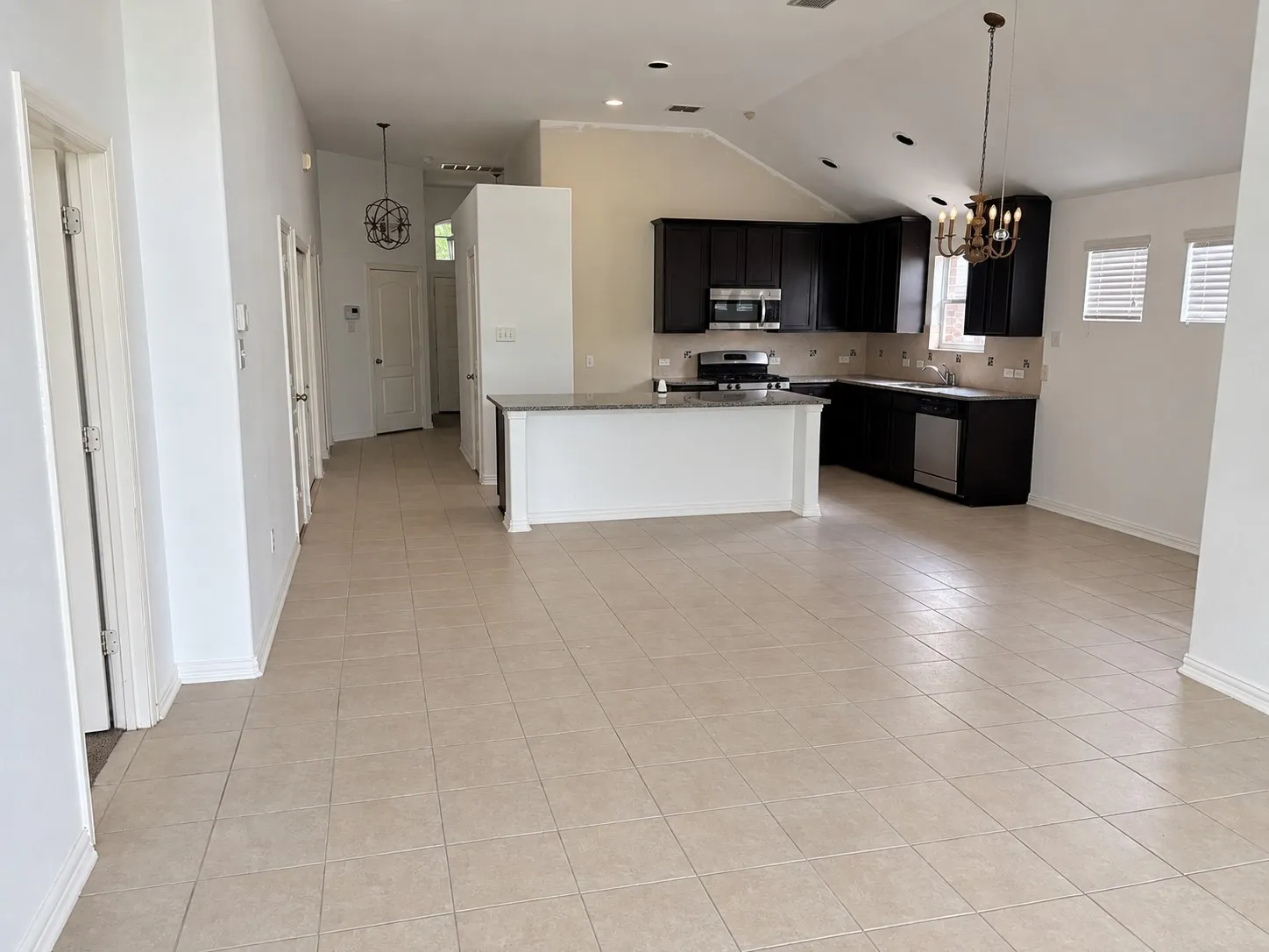 Kitchen featuring dark cabinetry, stainless steel appliances, and a breakfast bar with a light-colored countertop