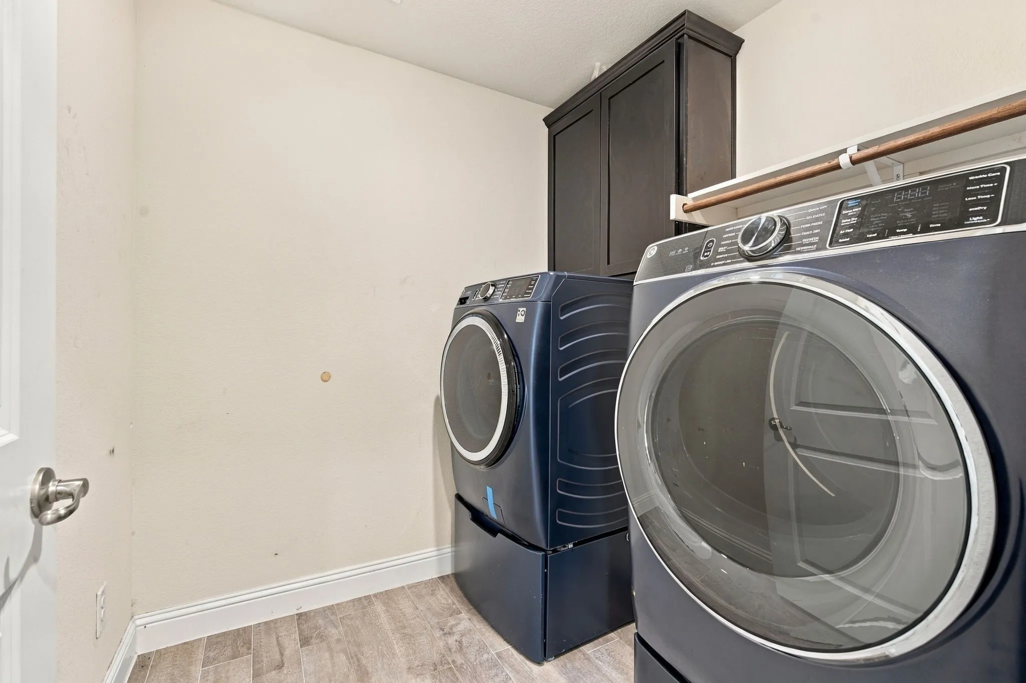 Built-in cabinetry, wood-finish flooring, and a door with brushed nickel hardware