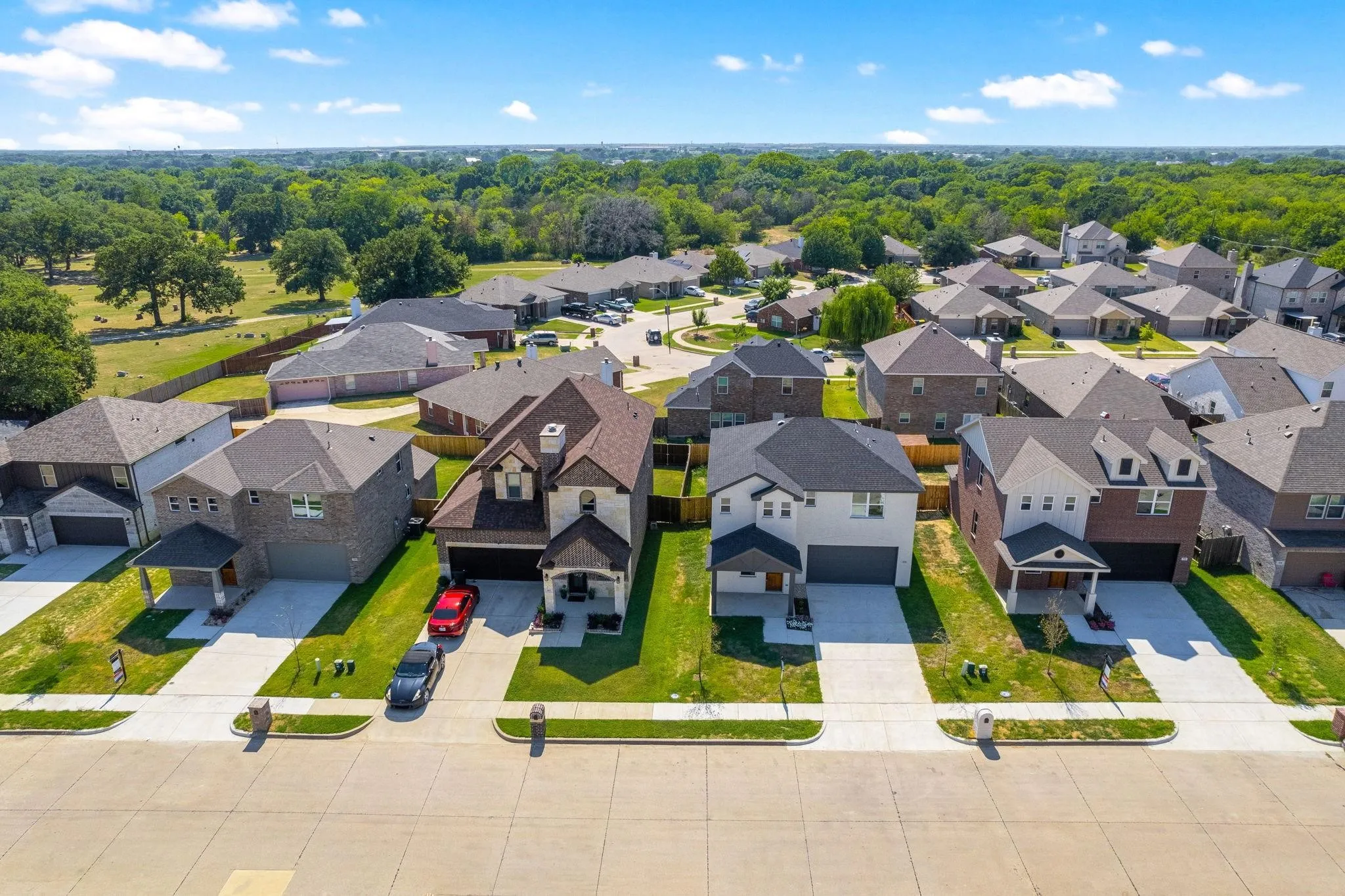 Residential neighborhood featuring single-family homes with pitched roofs, varied exterior finishes, and attached garages