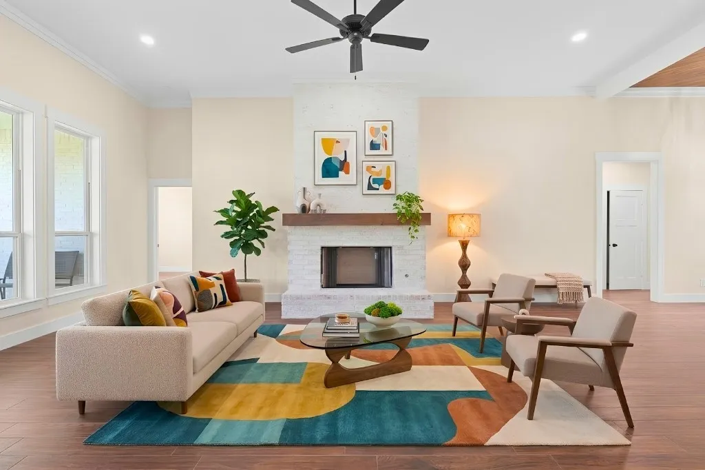 Vaulted ceiling with exposed wood beams, white brick fireplace with wood mantel, recessed lighting, wood-finish flooring, and multiple windows